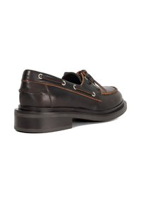 Brown leather shoe with a round toe and low stacked heel. Features contrasting stitching, metal eyelets, and a smooth texture.