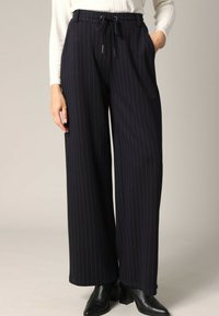 Marinekleurige pantalon met wijde benen en verticale witte streepjes, gemaakt van een gladde stof. Beschikt over een elastische tailleband metkoord en zijzakken.