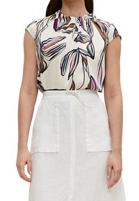 Blusa de manga corta en crema con un patrón floral en rosa, marrón y azul. Presenta un escote plisado y un detalle de ojal con botón.