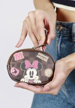 Monedero marrón con cremallera que presenta un diseño de Minnie Mouse, un lazo rosa y varios parches coloridos. Textura suave con herrajes en tono dorado.