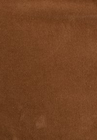Tejido de pana marrón con textura de estrías verticales, suave al tacto y de color uniforme. Adecuado para tapicería o prendas de vestir.