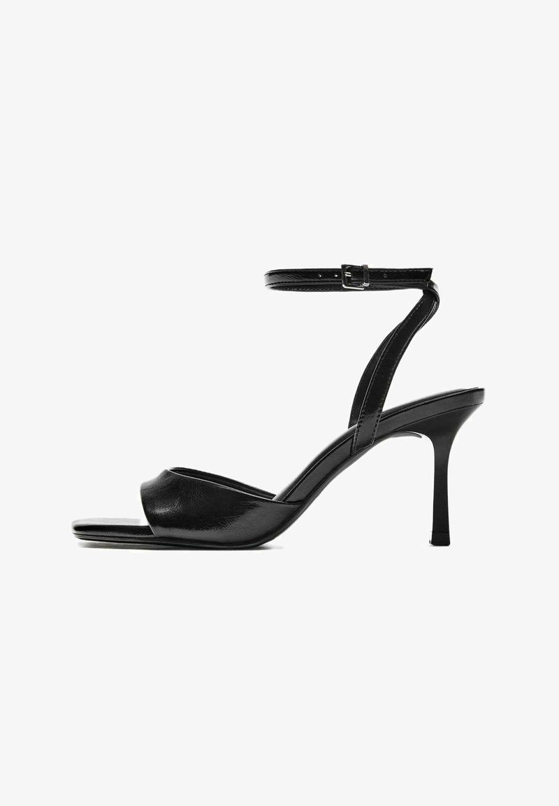 Sandale à talon haut en cuir noir avec bout ouvert, fine bride de cheville avec boucle et talon effilé.