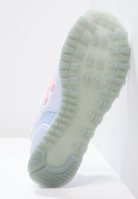 Baskets légères avec une tige blanche, des accents bleu pastel et des détails corail. Dotées d'une semelle extérieure texturée et translucide avec une bande de roulement à motif.