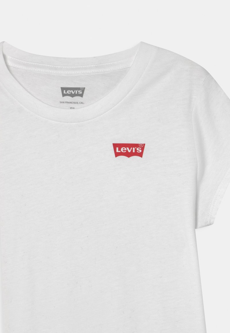 Camiseta de algodón blanca con escote redondo, mangas cortas y un logo rojo de Levi's en el lado izquierdo del pecho, con una textura suave y agradable al tacto.