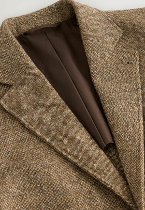 Sacou din tweed maro cu un țesut texturat, rever ascuțit și căptușeală interioară maro. Fără butoane vizibile; detalii de design ajustate sunt prezente.