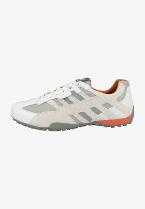 Scarpa sportiva bianca e grigia con dettagli arancioni, pannelli in rete, sovrapposizioni in suede e chiusura con lacci, vista di lato su uno sfondo bianco.