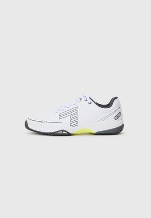 White athletic shoe with black accents and gray details. Features a textured upper, laces, and a bright yellow sole segment.