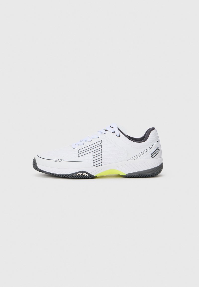 Pantofii sport albi cu accente negre și detalii gri. Au un superior texturat, șireturi și un segment al tălpii de un galben strălucitor.