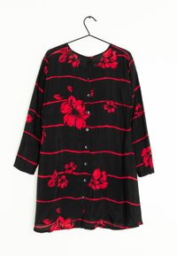 Svart skjorta med röd blommönster och horisontella ränder, med rund halsringning och knapplist framtill.