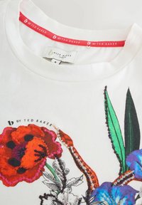 Witte katoenen T-shirt met een ronde hals, voorzien van kleurrijke bloemenbroderie in rood, blauw en groen, met een gestikt logo-label.