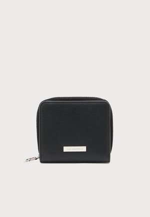 Portefeuille en cuir noir de forme rectangulaire, fermeture zippée, texture lisse et logo en métal argenté sur le devant.