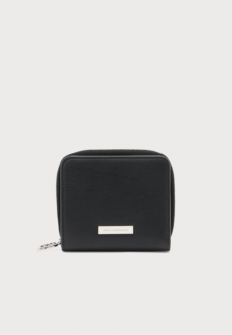 Μαύρο δερμάτινο πορτοφόλι με ορθογώνιο σχήμα, κλείσιμο με φερμουάρ, λεία υφή και ασημένιο λογότυπο από μεταλλικά στοιχεία στο εμπρός μέρος.