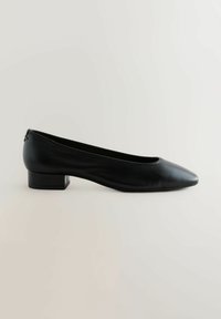 Bailarinas de cuero negro con punta afilada y tacón cuadrado bajo. Textura suave con un diseño minimalista y sin adornos visibles.
