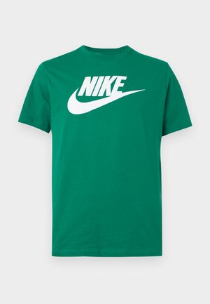 Vihreä Nike T-paita lyhyillä hihoilla, jossa suuri valkoinen Nike-logo ja swoosh keskellä rintaa, esitetty yksivärisellä valkoisella taustalla.