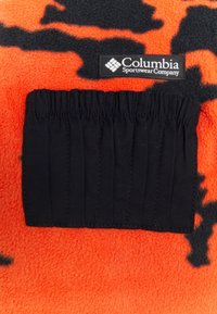 Columbia fleece in bright orange with a black spotted pattern. Features a black fabric pocket with six elastic sections for holding items.