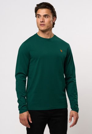 Langarmige groene shirt van zachte stof met een ronde hals en een klein oranje logo op de borst. Eenvoudig ontwerp met een relaxte pasvorm.