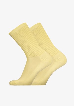 Gelbe Baumwollsocken mit Rippendesign, die eine glatte Textur und eine standardmäßige Knöchelhöhe aufweisen. Im Bild sind zwei Paare abgebildet.