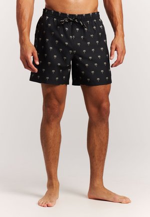 Black swim shorts with a palm tree pattern, elastic waistband featuring a drawstring, and a relaxed fit. Material appears lightweight and breathable.