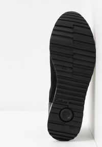 Black ankle boot with a textured rubber sole, featuring a low heel and a suede upper. Marked with "Gabor" and "Made in Slovakia."