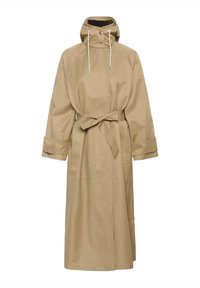 Béžový dlouhý plášť do deště s kapucí, nastavitelným stahovacím šňůrkou, patentními knoflíky, širokými manžetami a páskem v pase uvázaným na mašli.