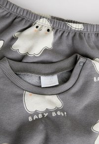 Hall beebide dressipluus kummitusprindiga, millel on soonikkoes ümara kaelusega ja dekoratiivne tekst "BABY BOO!" valges. Materjal on pehme puuvillasegu.