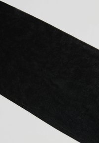Un morceau de tissu rectangulaire noir avec une surface douce et légèrement texturée sur un fond gris clair.