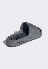 Gray slip-on sandal made of rubber with a ridged design, open toe, and perforated sole for ventilation. Smooth texture and rounded shape.