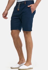 Marineblaue Shorts aus leichtem Stoff. Mit Seitentaschen, Kordelzugbund mit dekorativen Enden und geradem Schnitt.