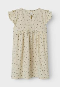 Robe jaune clair avec un motif floral en marron et vert, manches courtes avec volants et une ouverture en forme de trou de serrure avec boutons à l'arrière.