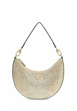 Sac à main beige en forme de croissant avec une bandoulière noire, orné de clous dorés et argentés, avec un petit logo triangulaire Guess sur le devant.