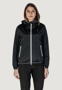 Giacca leggera nera con zipper frontale, due tasche laterali con zip, colletto alto e logo sul petto. Presenta polsini elastici.