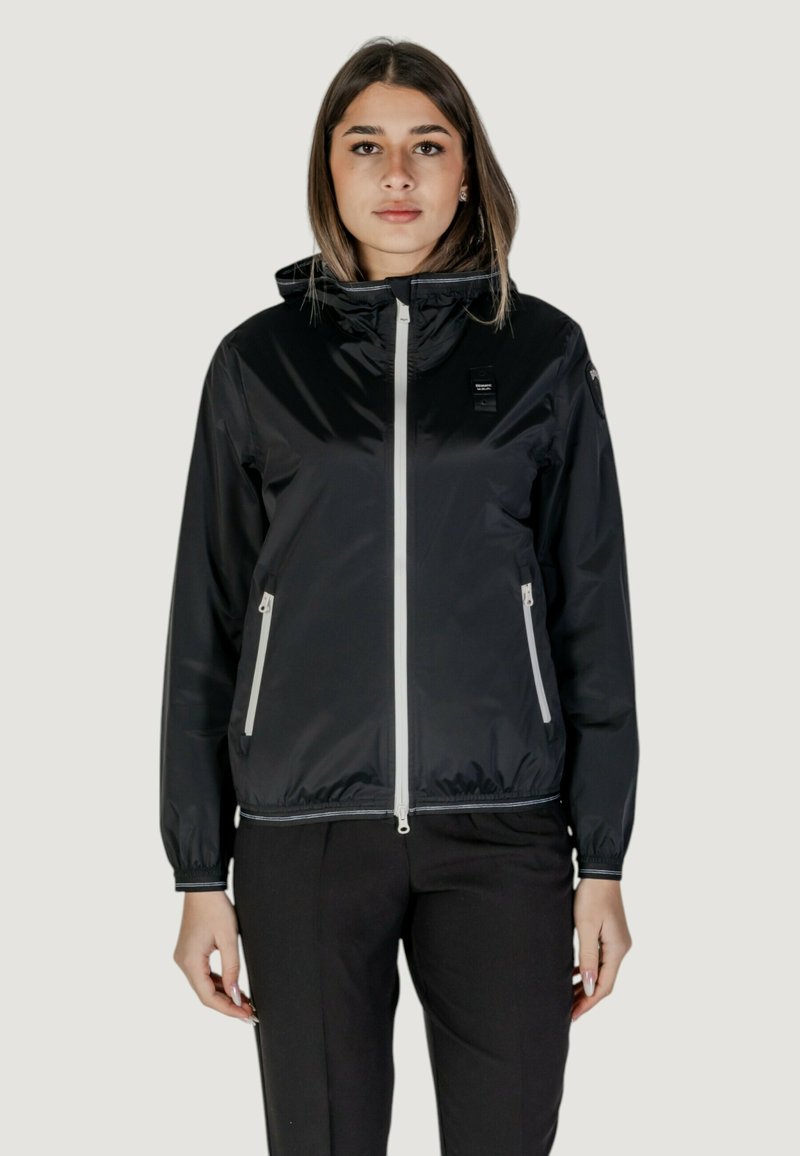 Giacca leggera nera con zipper frontale, due tasche laterali con zip, colletto alto e logo sul petto. Presenta polsini elastici.