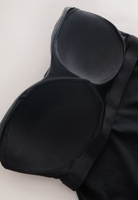 Sort støbt BH med en glat finish. Har et sømløst design og bred bånd for støtte. Blød stoftekstur og ingen synlige hårde dele.