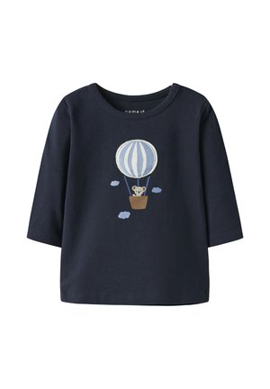 Camiseta azul marino de manga larga para niño pequeño con un globo aerostático azul y blanco y un koala en la cesta, rodeado de pequeñas nubes.