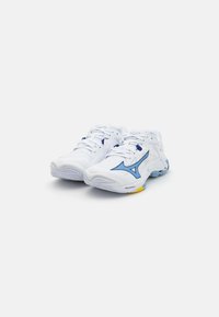 Baskets blanches avec accents bleus, tige en mesh, semelle texturée et logo bien visible. Comprend des lacets et un rembourrage pour le soutien.