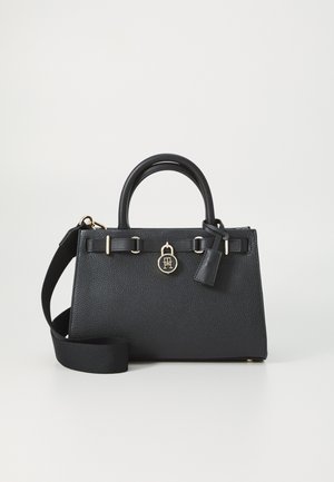 Melna ādas rokassoma ar teksturētu virsmu, diviem rokturiem un noņemamu siksniņu. Iespējas ar zelta toņa furnitūru un logotipa piekariņu.