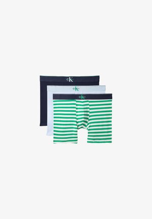 Drie gestapelde herenboxers, kleuren van voor naar achter: groen-witte strepen, effen wit, effen marineblauw, elk met een Calvin Klein tailleband.
