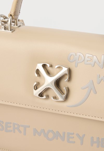 Μπεζ δερμάτινη τσάντα με ασημένιο κούμπωμα σε σχήμα Χ και ασημένιο κείμενο που λέει "ΑΝΟΙΞΤΕ," με ένα βέλος και μερικές λέξεις "ΕΙΣΑΓΩΓΗ ΧΡΗΜΑΤΩΝ ΕΔΩ."