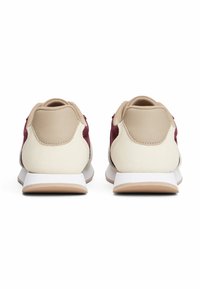 Sneakers with a beige synthetic upper, maroon accents, and a white midsole; textured back heel support; layered design.