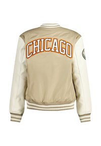 Beige bomber-takki, jossa on kermaiset nahkahihat. Selässä on suurikokoinen oranssi "CHICAGO"-teksti ja raidoitetut hihansuut. Suchmalinen pinta ja moderni muotoilu.