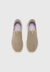 Sneaker slip-on beige con tomaia in maglia testurizzata, soletta imbottita e suola in gomma bianca. Presenta un sottile accento viola sulla soletta.