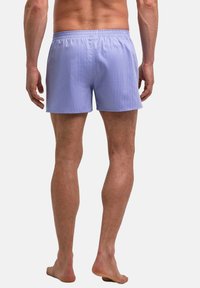 Shorts pour hommes bleu clair avec une ceinture élastique, une texture lisse et un design simple. Le tissu présente de subtiles rayures verticales.
