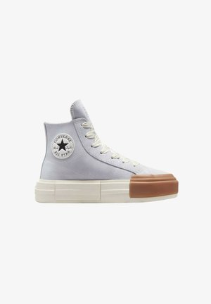 Zapatilla alta en lona gris claro con punta redonda y suela gruesa y chunky. Presenta un logo de estrella negra y acentos texturizados en la punta.