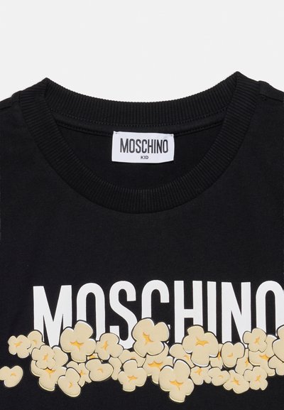 Μαύρο παιδικό μπλουζάκι Moschino με λευκή επωνυμία και σχέδιο ποπκόρν στο στήθος κάτω από το λαιμόκοψη.