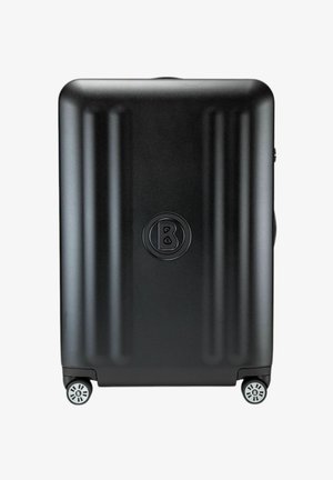 Maleta rígida negra con surcos verticales, cuatro ruedas, logo en relieve en el centro, textura lisa y diseño minimalista.