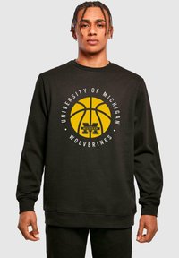 Felpa nera con una grafica bianca che raffigura un pallone da basket e il testo "University of Michigan Wolverines" in giallo e nero.