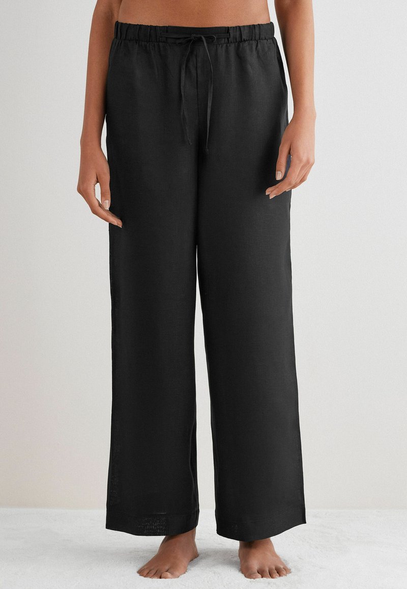 Svarta, löst sittande linbyxor med dragsko i midjan och vida ben, med en slät yta och utan synliga mönster eller detaljer.