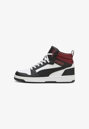Sneaker alta nera e bianca con un mix di materiali in pelle e sintetici, dettagli rossi e lacci bianchi con suola in gomma texture.