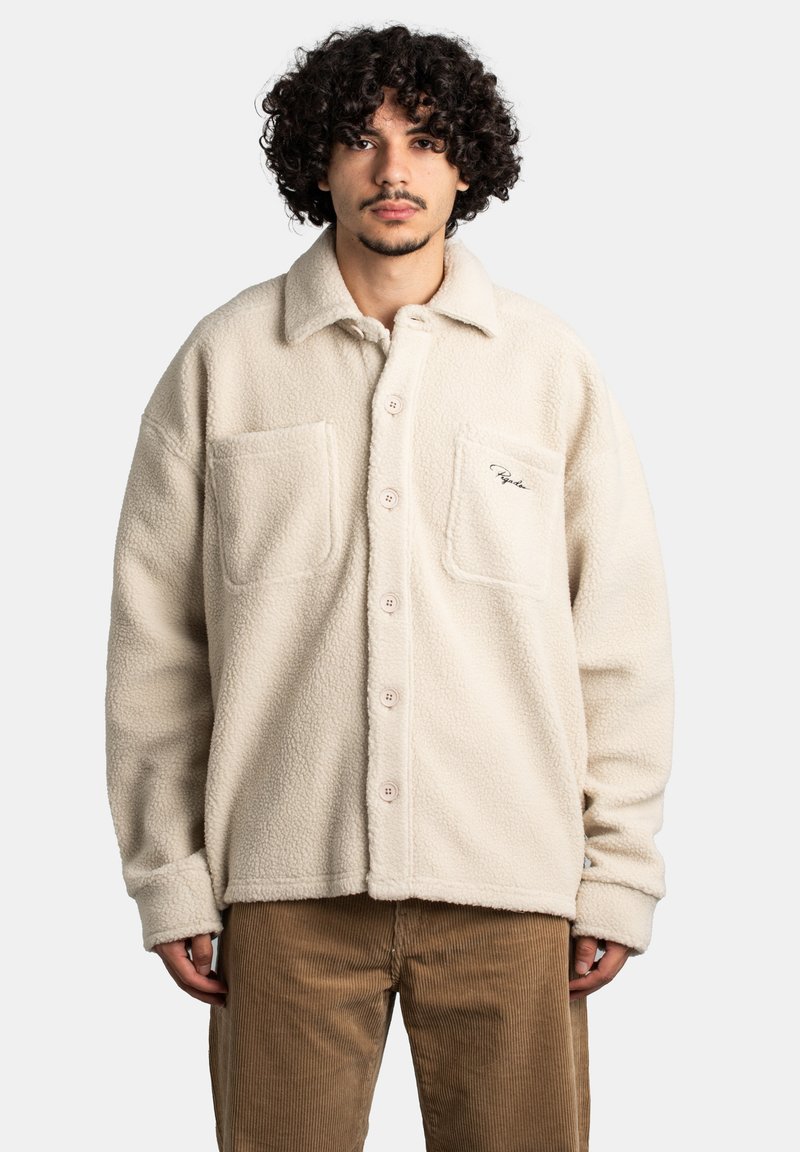 Kremowa polarowa kurtka z dwoma kieszeniami na piersi, dużymi guzikami i miękką fakturą. Posiada haftowane logo na lewej kieszeni.