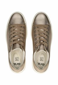 Zapatillas metálicas de bronce con cordones, con parte superior de cuero suave, puntera redonda y suela de goma blanca contrastante. El interior cuenta con un suave forro.